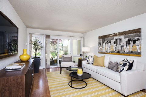 a living room with a white couch and a yellow striped rug